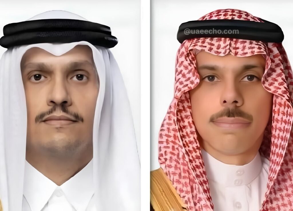 Two men in Gulf traditional dress side by side, left in white kandura and black agal, right in red‑and‑white shemagh with agal and white thobe.